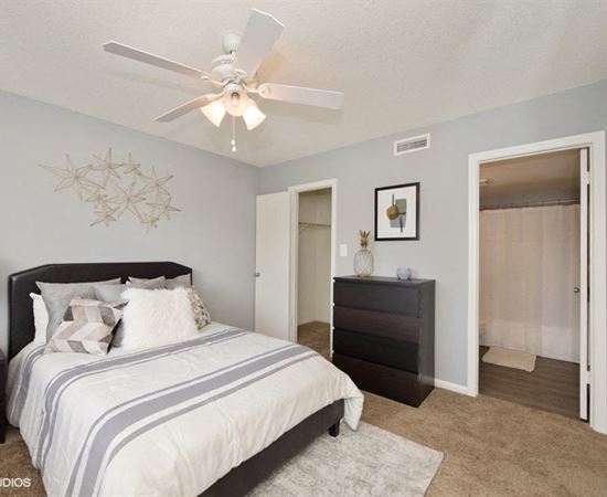 a bedroom with a bed and a ceiling fan